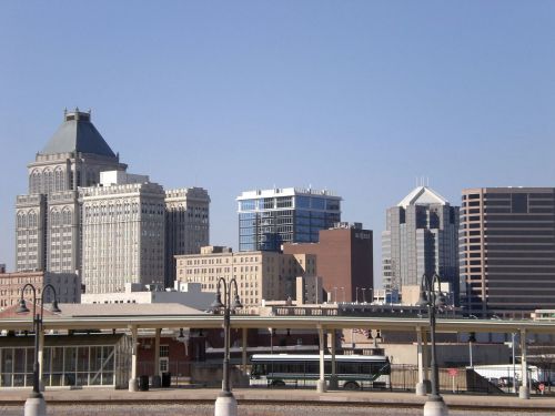 City skyline featuring a mix of historic and modern buildings under a clear blue sky.