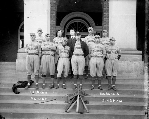 A vintage baseball team poses on steps, wearing matching uniforms with "Mebane" and "Bingham" printed on them.