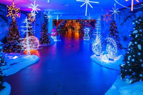 A festive hallway adorned with illuminated Christmas trees and snowflakes, creating a winter wonderland atmosphere.