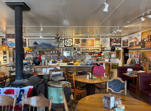 Cozy diner interior with wooden tables, a stove, vintage decor, and a welcoming atmosphere.