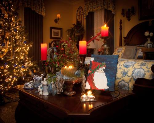 A cozy holiday scene with a decorated Christmas tree, candles, and festive decor on a wooden table.
