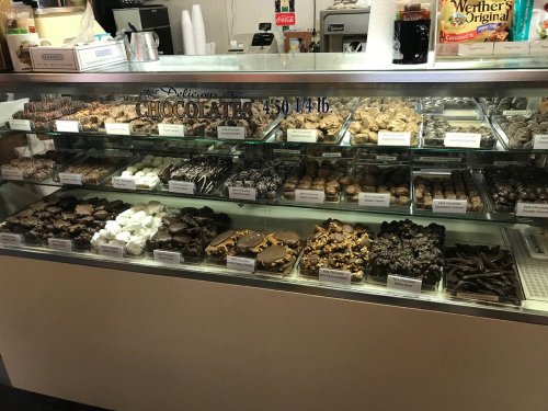 A display case filled with various chocolates and confections, including truffles, fudge, and chocolate-covered treats.