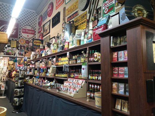 A vintage store display featuring shelves filled with various retro products and nostalgic signage.