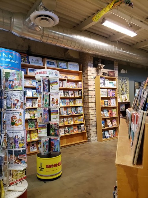 A cozy bookstore interior featuring shelves of children's books and a warm, inviting atmosphere.