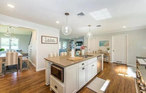 Bright, modern kitchen with an island, pendant lights, and a dining area in a spacious, open layout.