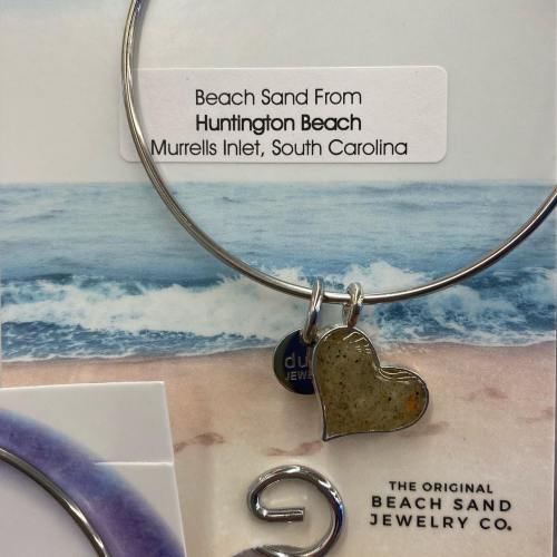 A silver bracelet featuring a heart charm and a tag labeled "Huntington Beach, Murrells Inlet, South Carolina."