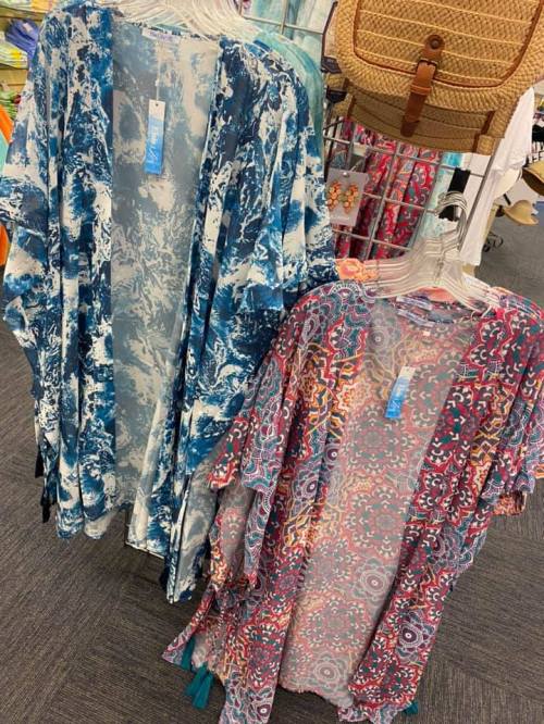 Two colorful kimonos hang on display: one in blue and white patterns, the other in pink and floral designs.