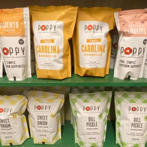 A display of Poppy popcorn bags in various flavors: Pimento Cheese, Tangy Carolina Barbecue, Sweet Onion, and Dill Pickle.