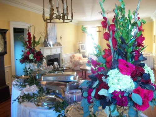 A beautifully arranged dining table with floral centerpieces and elegant serving dishes in a bright, inviting room.