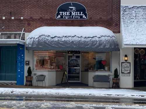 A cozy coffee shop, "The Mill," with a snow-covered awning and a wintery street scene in front.