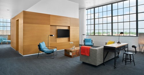 Modern living space with large windows, wooden accents, colorful furniture, and a cozy atmosphere.