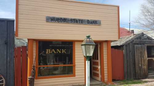 Exterior of Murdo State Bank, featuring a sign above the entrance and a vintage lamp post in front.