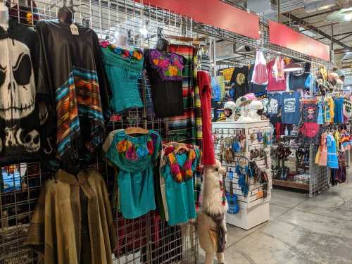 Colorful clothing and accessories displayed on racks in a vibrant market setting.