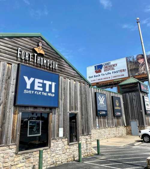 Exterior of Fort Thompson store with YETI signage, under a clear blue sky and a billboard for Cabot Emergency Hospital.