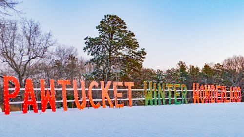 Colorful letters spell "Pawtucket Winter Wonderland" against a snowy landscape with trees in the background.