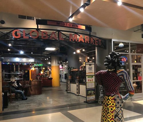Entrance to Midtown Global Market featuring colorful sculptures and a vibrant marketplace atmosphere.