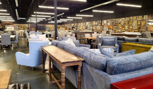 A spacious furniture store filled with various sofas, chairs, and tables, featuring a modern industrial design.