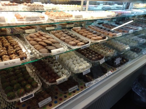 A display case filled with various types of chocolates and confections, neatly arranged on trays.