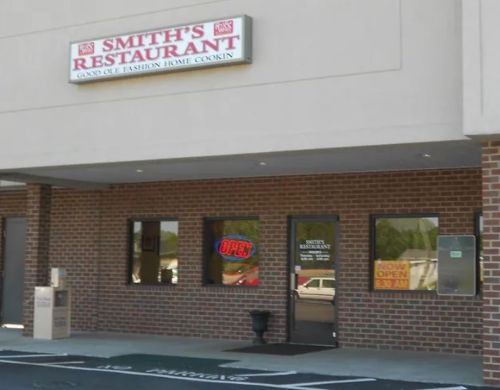 Exterior of Smith's Restaurant with a sign reading "Open" and a brick facade.