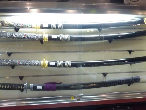 A display case featuring several ornate swords with intricate designs and decorative handles.