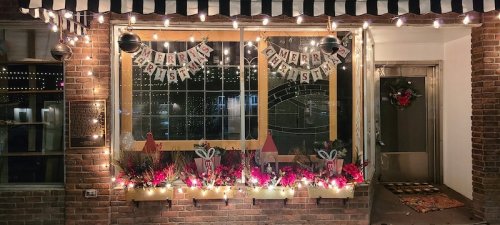 A festive window display with lights, a "Merry Christmas" banner, and holiday decorations.