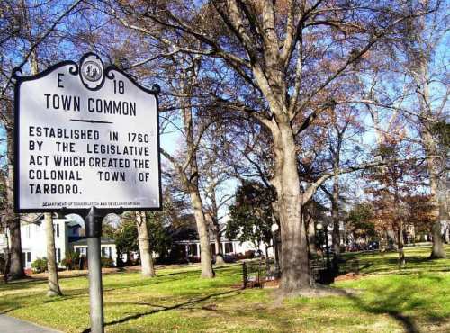 Sign marking the Town Common, established in 1760, with trees and a park area in the background.