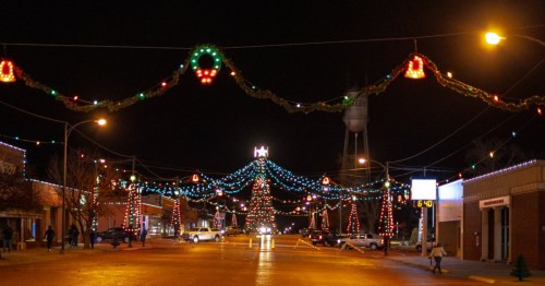 a wide shot of the tall christmas tree with string lights around downtown wakeeney kansas at night