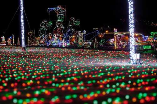 Colorful holiday lights create a festive scene with red and green patterns against a dark night sky.