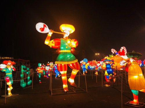 Colorful lanterns depicting musicians and performers in a festive night setting.