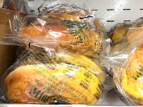 Packaged baked goods in plastic wrap, displayed on a shelf in a store.