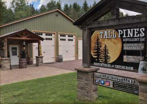 Exterior of Tall Pines Distillery with a wooden sign, garage doors, and a rustic entrance surrounded by trees.