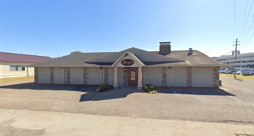 A single-story building with a peaked roof and stone accents, featuring a sign that reads "Gengy's."
