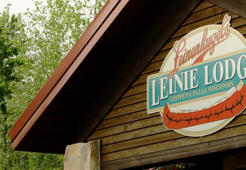 Sign for Leinie Lodge in Chippewa Falls, Wisconsin, featuring a wooden structure and green and red lettering.