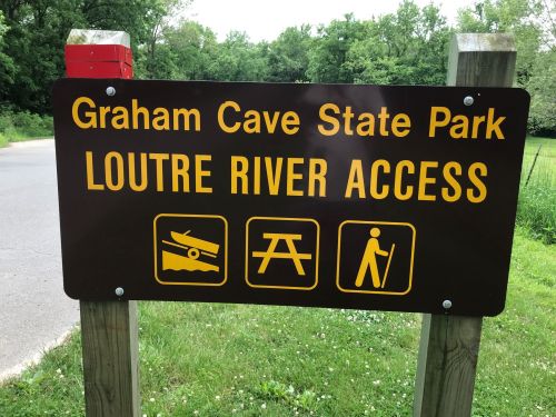 Sign for Graham Cave State Park indicating access to Loutre River, featuring icons for kayaking, picnicking, and hiking.
