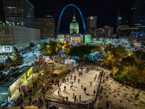 A vibrant night scene of an ice skating rink surrounded by festive lights and the St. Louis Arch in the background.