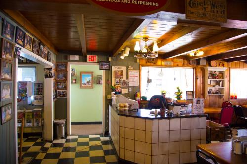 Cozy diner interior with checkered floor, wooden beams, and walls adorned with photos and memorabilia.