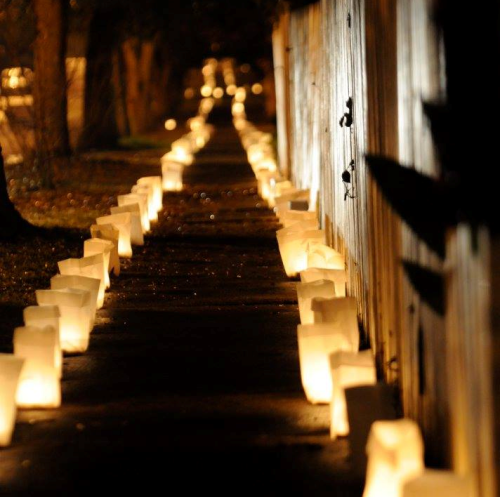 A dimly lit pathway lined with glowing lanterns, creating a warm and inviting atmosphere.