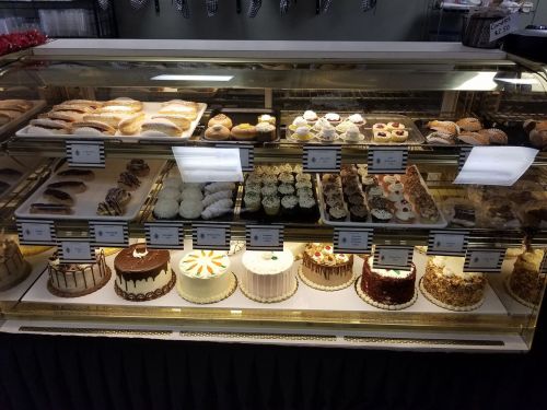 A display case filled with various baked goods, including pastries, cupcakes, and decorated cakes.