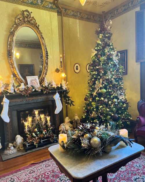 A cozy room decorated for Christmas, featuring a tree, stockings, a fireplace, and festive ornaments.