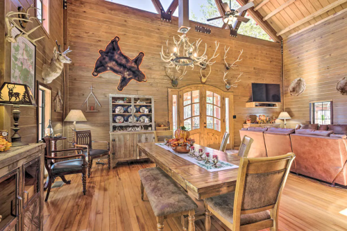 Cozy wooden interior of a cabin with a dining table, antler decor, and a warm, inviting atmosphere.