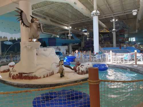 Indoor water park featuring a snowy theme, water slides, and a pool with inflatable rings and seating areas.