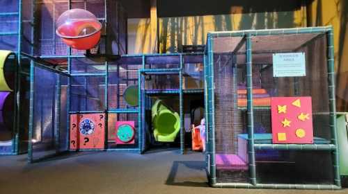 Colorful indoor play structure with tunnels, slides, and climbing areas, designed for children's play and exploration.