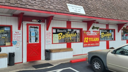 Exterior of Henri's Barbecue restaurant, featuring red and white decor, celebrating 12 years in business.