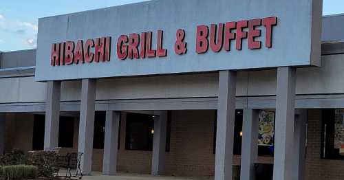 Sign for "Hibachi Grill & Buffet" on a building exterior, with a clear blue sky in the background.