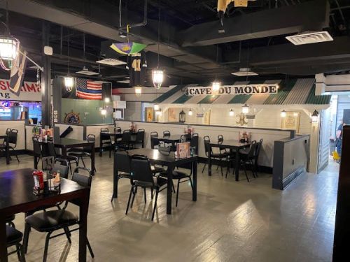 Interior of a casual dining restaurant with black chairs, tables, and decorative elements like flags and signs.