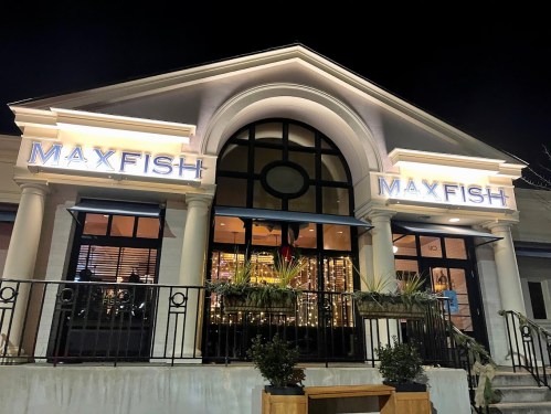 Exterior of Maxfish restaurant at night, featuring illuminated signage and a welcoming entrance.