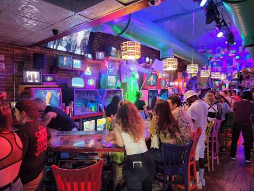 A vibrant bar scene with colorful lights, retro decor, and a lively crowd enjoying drinks and entertainment.