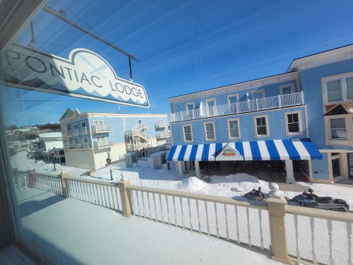 View from Pontiac Lodge showing snow-covered streets and buildings under a clear blue sky.