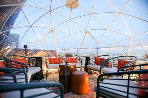 A cozy, transparent geodesic dome interior with seating and a view of the outdoors.