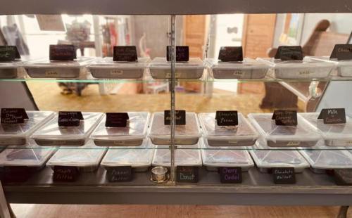 Display case filled with various dessert containers, each labeled with names and prices.